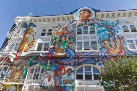 Une fresque murale colorée à grande échelle recouvre le côté du Women's Building dans le 县团 de San Francisco.